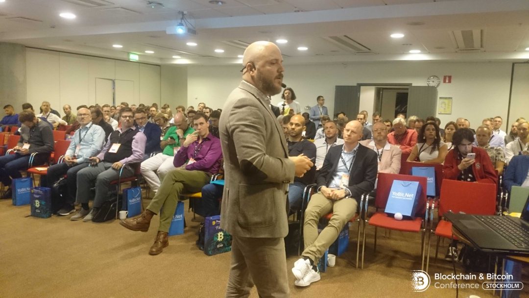 A speaker at the Blockchain and Bitcoin conferene in front of the audience at Stockholm